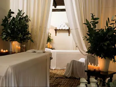 a bedroom with a bed with candles and plants at Inkaterra Machu Picchu Pueblo Hotel in Machu Picchu