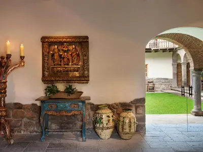 a room with a table and two vases on a wall at Inkaterra La Casona Relais & Chateaux in Cusco
