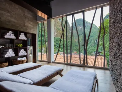 a living room with a large window with a view at El MaPi by Inkaterra in Machu Picchu