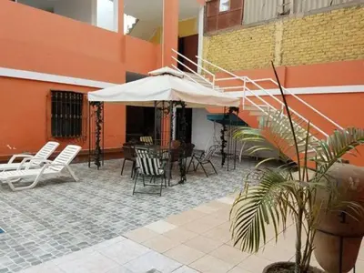 a patio with a table and chairs and an umbrella at Hotel Princess in Ica