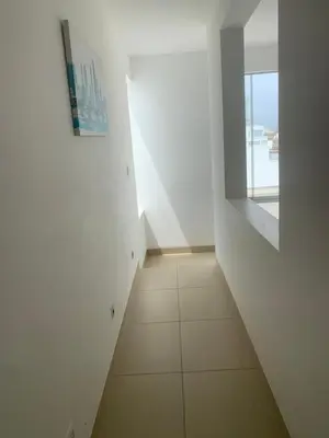 a hallway with a white wall and a tile floor at Condominios Nauticos Nuevo Paracas in Paracas