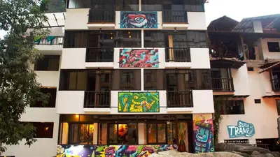 a building with paintings on the side of it at Supertramp Hostel Machupicchu in Machu Picchu