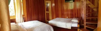 a small room with two beds and a ladder at Refugio de Orquídeas in Oxapampa