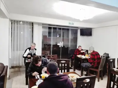a group of people sitting at tables in a restaurant at Machupicchu Guest House in Machu Picchu