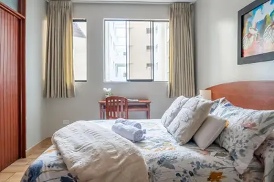 a bedroom with a bed and a table and windows at Imperial Inn Hospedaje Turistico in Lima