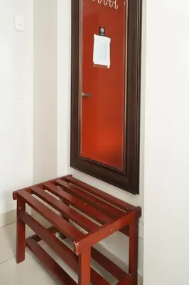 a wooden bench sitting in front of a mirror at Imperial Inn Hospedaje Turistico in Lima