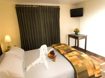 a hotel room with a bed with a bowl of fruit on it at Hostal Samichay in Cusco