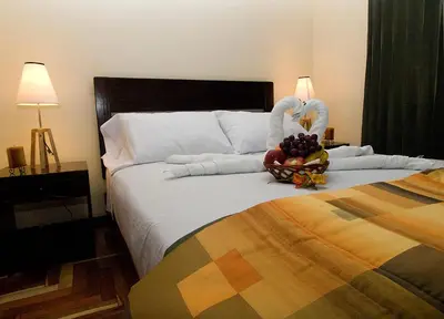 a bedroom with a bed with a bowl of fruit on it at Hostal Samichay in Cusco
