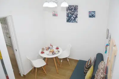 a dining room with a white table and white chairs at Barranco Wasi in Lima