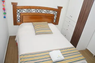 a bed with a wooden headboard in a room at Barranco Wasi in Lima