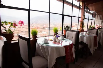 a restaurant with tables and chairs with a view at Hostal Tu Hogar in Cusco