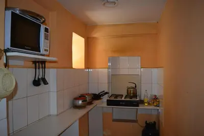 a small kitchen with a microwave and a stove at El Tuco Hotel in Cusco