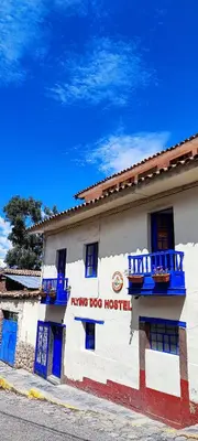 a building with blue doors and a living dog hospital at Flying Dog Hostel Cusco in Cusco