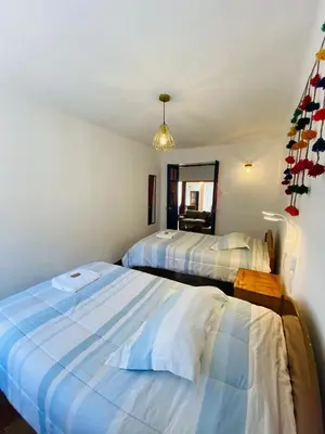 a bedroom with two beds and a mirror at Flying Dog Hostel Cusco in Cusco