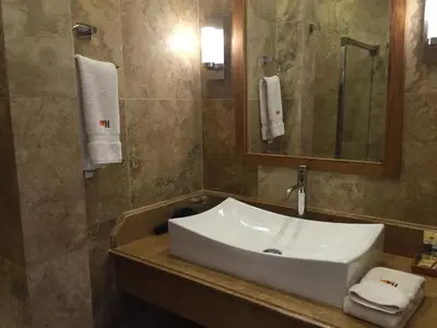 a bathroom with a white sink and a mirror at Taypikala Hotel Cusco in Cusco