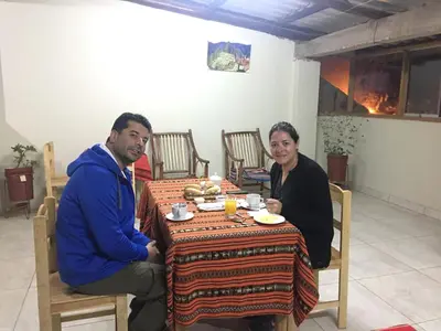 a man and a woman sitting at a table at Hostal Apu Qhawarina in Ollantaytambo