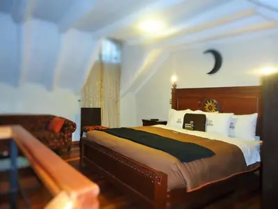 a bedroom with a large bed and a couch at Hotel San Francisco Plaza in Cusco