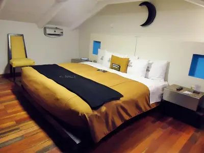 a bedroom with a large bed with a yellow blanket at Hotel San Francisco Plaza in Cusco