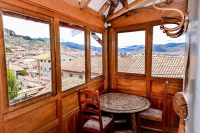 a room with a table and chairs and windows at El Balcón in Cusco