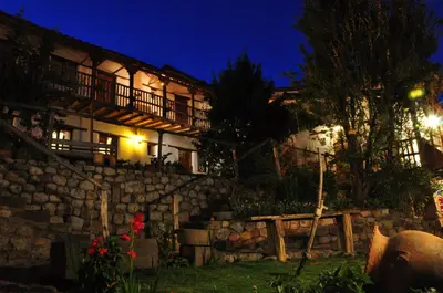 a building with a stone wall at night at El Balcón in Cusco