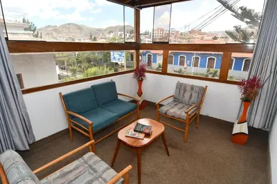 a living room with chairs and a table and a window at Centenario Inn in Cusco