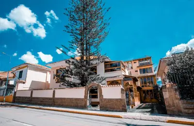 a tree in front of some buildings on a street at Centenario Inn in Cusco