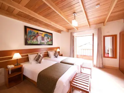 a bedroom with two beds and a large window at Sol Ollantay Boutique Hotel in Ollantaytambo
