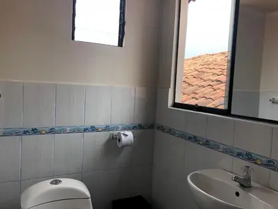 a bathroom with a toilet and a sink and a window at Casa Salkantay Cusco in Cusco