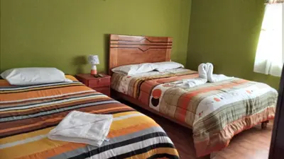 two beds in a room with green walls at Casa Salkantay Cusco in Cusco
