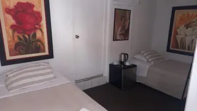 a bedroom with two beds and a painting on the wall at Jose Luis Hostal Boutique in Lima
