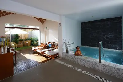 a living room with a swimming pool with people sitting in it at Hotel Las Dunas in Ica