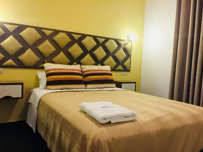 a bedroom with a bed with two towels on it at Hostal Patiño in Lima