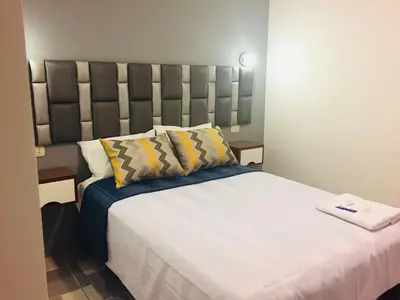 a bedroom with a large bed with a large headboard at Hostal Patiño in Lima