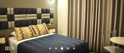 a bedroom with a bed with a blue and white headboard at Hostal Patiño in Lima