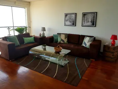 a living room with a brown couch and a coffee table at Malecón in Lima