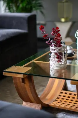 a vase with red flowers sitting on a glass table at Departamento en San Isidro, Lima in Lima