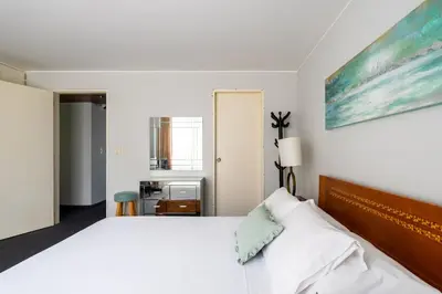 a bedroom with a white bed and a painting on the wall at Departamento en San Isidro, Lima in Lima