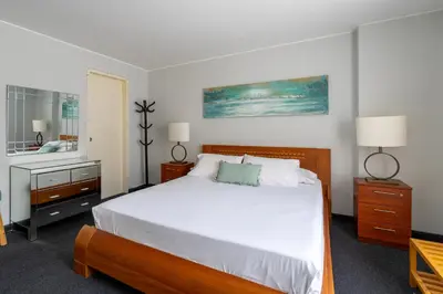 a bedroom with a large white bed and a mirror at Departamento en San Isidro, Lima in Lima