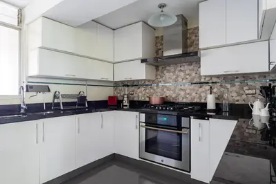 a white kitchen with white cabinets and appliances at Departamento en San Isidro, Lima in Lima