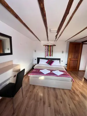 a bedroom with a bed and a desk and a chair at Casona les Pleiades in Cusco