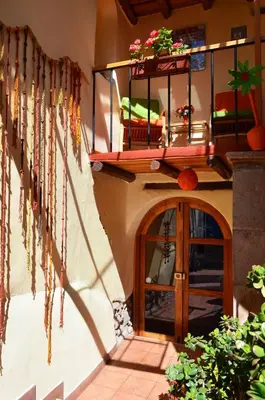 a building with a wooden door and a balcony at Casona les Pleiades in Cusco