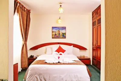 a hotel room with a bed with two towels on it at Apart Hotel Caminos del Inca in Lima