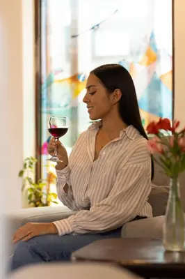 a woman sitting on a couch holding a glass of wine at Hostal Teatro Inka in Cusco