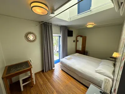a bedroom with a bed and a table and a window at Posada Villa Mayor in Cusco