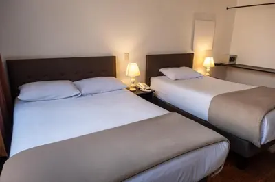 two beds in a hotel room with two lamps at Tika Wasi Casa Boutique in Cusco