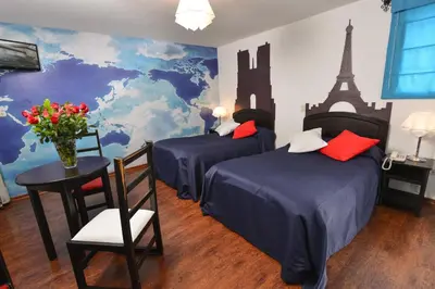 a bedroom with two beds and a mural of the eiffel tower at Tika Wasi Casa Boutique in Cusco
