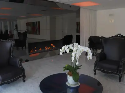 a living room with a fireplace and a table with flowers at NM Lima Hotel in Lima