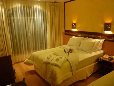a bedroom with a large white bed and a window at Hotel Taypikala Machupicchu in Machu Picchu