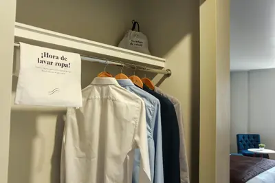 a closet with a rack of shirts and a sign at Hotel Unu in Huancayo
