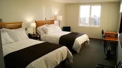 a hotel room with two beds and a window at Hotel Unu in Huancayo